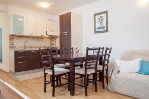 a kitchen and dining room with a table and chairs at Apartments Leut 80m from the Sea in Podgora