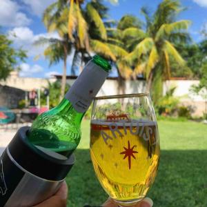 eine Person, die ein Weinglas mit einer Flasche hält in der Unterkunft CoCo Cozy Apartment Centric and Private in Cozumel