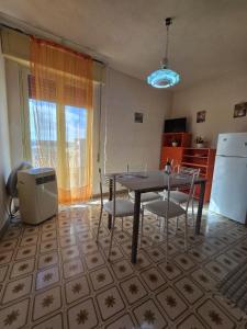 een keuken met een tafel, stoelen en een koelkast bij Regina Elena Apartment in Marzamemi +48 foto's