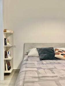 a bed in a white room with a book shelf at Casa Quarta in Camogli