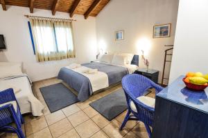 a bedroom with a bed and a table and chairs at Green Village in Xylokastro