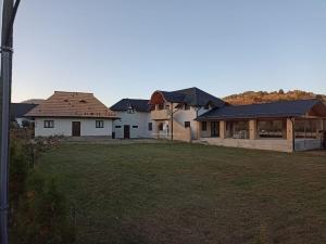 a group of houses in a field with a yard at Casa Delia in Mănăstirea Humorului