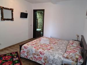 a bedroom with a bed and a mirror at Casa Delia in Mănăstirea Humorului