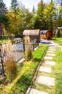 a garden with a fence and a house in the background at 2CH Relaxation Spa Sauna BBQ Wi-Fi in Pont-Rouge
