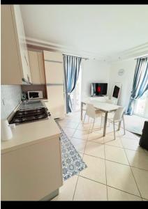 Una cocina y un comedor con mesa y sillas. en Appartamento Sul Mare, en Riccione