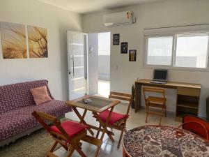 a living room with a couch and a table and a desk at Hospedagem Vista do Sol in Cachoeira do Sul