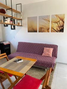 a living room with a purple couch and a table at Kitnets - Fornecemos NF in Cachoeira do Sul