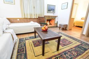 a living room with a table and a fireplace at Green Village in Xylokastro