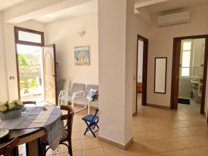 Un comedor y una sala de estar con mesa y sillas. en Accogliente a 2minuti dal mare, en Santa Maria Navarrese 7 fotos más