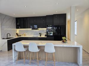 巴克里索莫雷诺港Pacific Haven的厨房配有带3张白色吧台凳的吧台