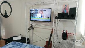 ein Wohnzimmer mit einem Fernseher auf einem Regal in der Unterkunft Renacer NATURAL GETAWAY MOVISTAR ARENA in Bogotá