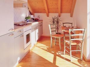 eine Küche mit weißen Schränken sowie einem Tisch und Stühlen in der Unterkunft Ferienwohnung Hütt in Wasserburg