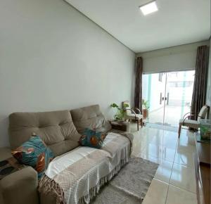 un soggiorno con un divano e una grande finestra di Casa com 3 quartos avenida oceânica a Salvador