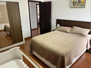 una camera da letto con un letto grande e uno specchio di Casa com 3 quartos avenida oceânica a Salvador