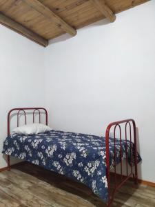 a bed in a room with a blue blanket on it at Che Sy ha Che Ru in Cosquín