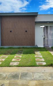 a house with a grassy yard in front of it at Casa aconchegante in Guanamby