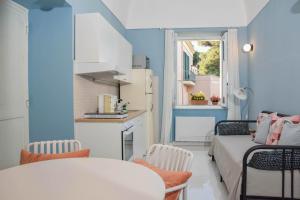 a small room with blue walls and a kitchen at La Casetta Pompei Sorrento Guest House Vesuvio in Boscotrecase