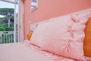 a bed with white pillows with bows on it at La Casetta Pompei Sorrento Guest House Vesuvio in Boscotrecase