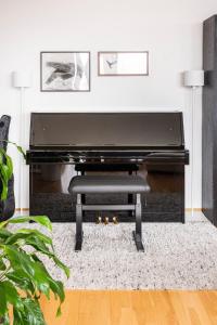 a black piano in a living room with a bench at Private room with views to the mountains in Reykjavík