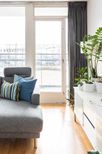 a living room with a couch and potted plants at Private room with views to the mountains in Reykjavík