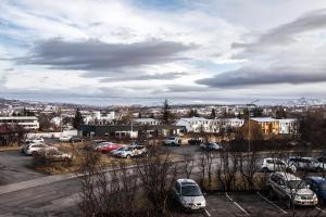 a parking lot with a bunch of cars parked at Private room with views to the mountains in Reykjavík
