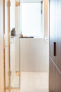 a shower with a glass door in a bathroom at Private room with views to the mountains in Reykjavík