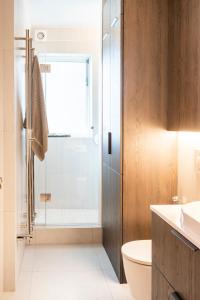 a bathroom with a shower and a toilet and a sink at Private room with views to the mountains in Reykjavík