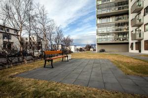 a bench in a park next to a building at Private room with views to the mountains in Reykjavík