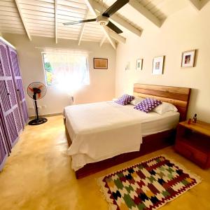 a bedroom with a bed and a ceiling fan at Casa Del Sol in El Limón