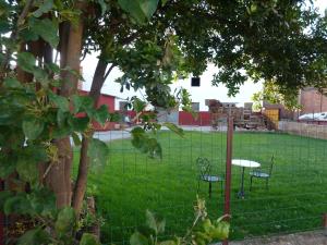 a green field with a red fence and a red fire hydrant at Hostal A La Sombra Del Laurel in Navarrete