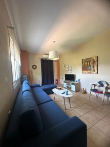 a living room with a blue couch and a table at Vafkeri Apartments in Vavkerí