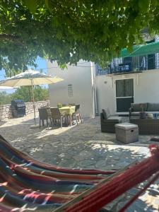 a patio with an umbrella and a table and chairs at Vafkeri Apartments in Vavkerí