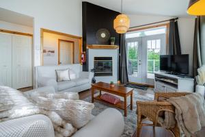 a living room with a couch and a tv at Panoramic view 2CH Fireplace BBQ Terrace - High Unit in Petite-Rivière-Saint-François