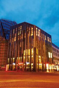 a large building with many windows at night at abito Suites in Leipzig