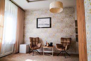 2 Stühle und ein Tisch in einem Zimmer mit Tapete in der Unterkunft Dom na Podwalu in Lublin + 67 Fotos