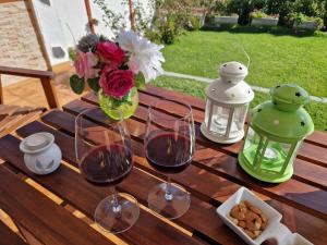 two glasses of wine and a vase of flowers on a wooden table at Casas Hoya Limpia- Sólo Adultos in Santa Cruz de la Palma