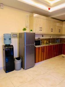 a kitchen with stainless steel appliances and wooden cabinets at Azure Atrium Abode one bedroom family apartment in Rawalpindi