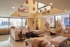 a living room with couches and chairs and windows at Amazing PH in Poblado 5BD & heated pool! in Medellín