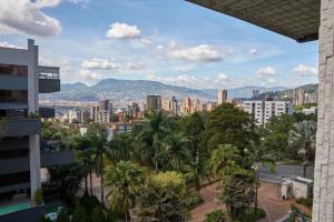 a view of a city with palm trees and buildings at Amazing PH in Poblado 5BD & heated pool! in Medellín