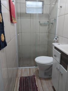 a bathroom with a shower and a toilet and a sink at Casa na praia do sonho in Palhoça