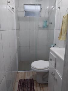a white bathroom with a toilet and a shower at Casa na praia do sonho in Palhoça +3 photos