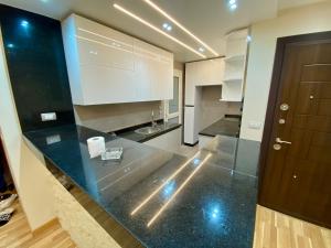 cocina con encimera negra y puerta marrón en Relaxing stay ready Anytime Free Wifi, en Madinaty