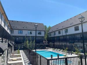 a courtyard with a swimming pool between two buildings at Enchanted Mountain Getaway in Canmore