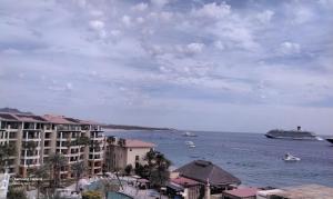 卡波圣卢卡斯Medano Beach suites的船上有建筑物和船只