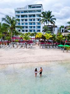a man and woman standing in the water on a beach at Boca Beach Residence hotel in Boca Chica