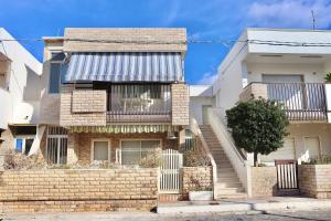 una casa in mattoni con una scala di fronte di Nido del Mar a Lendinuso
