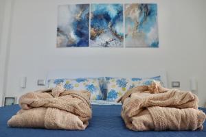 un paio di asciugamani posti sopra un letto di Nido del Mar a Lendinuso