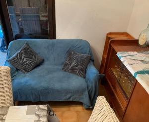 un canapé bleu avec deux oreillers dessus dans une pièce dans l'établissement Holiday house Les Lauriers-roses 6 persons, 1 km from the beach, à Vendres