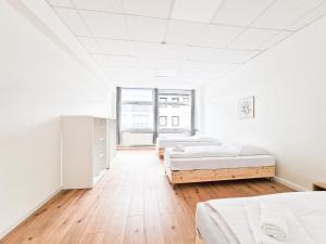 a white room with three beds and a window at Tolstov Apartments - City Center Apartments with 5 Rooms - 10 Min Messe DUS in Düsseldorf