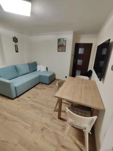 a living room with a blue couch and a table at Apartament " Uznam" w centrum Świnoujścia in Świnoujście